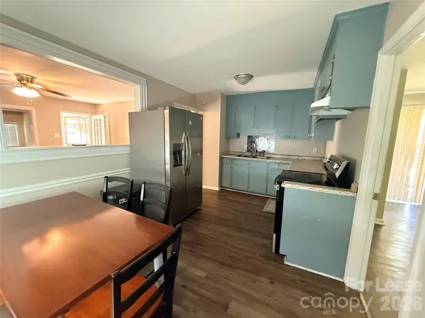 a kitchen with stainless steel appliances wooden floor dining table and chairs
