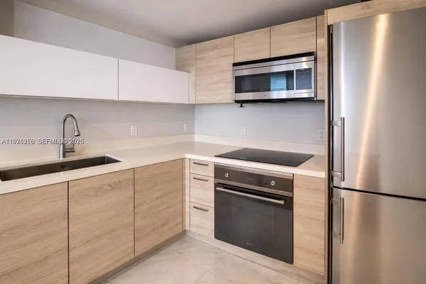 a kitchen with cabinets stainless steel appliances and sink