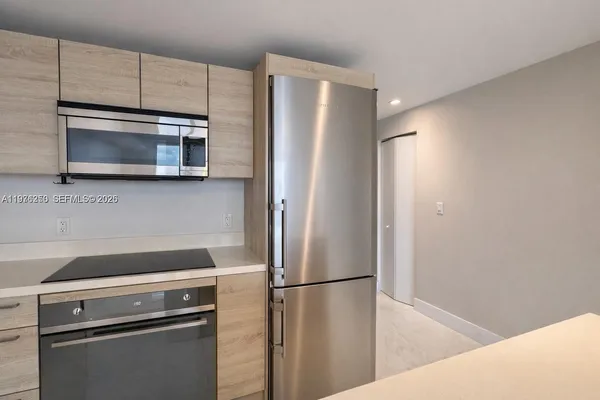 a kitchen with cabinets and stainless steel appliances