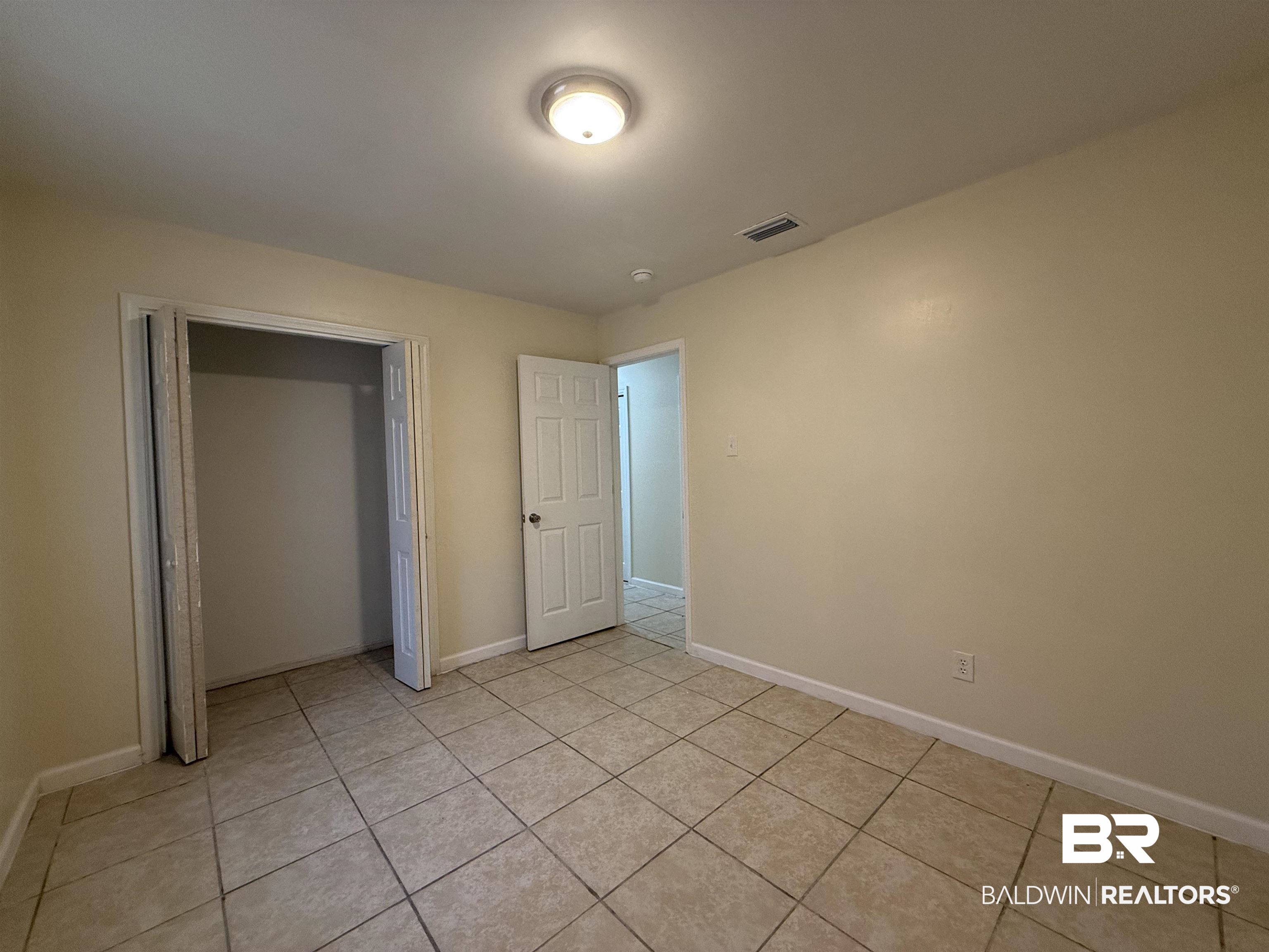 320 E Street Prichard, AL 36610 - Photo 12 of 16 Unfurnished bedroom featuring light tile patterned flooring and a closet
