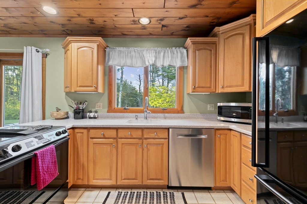 224 Snipatuit Road Rochester, MA 02770 - Photo 29 of 42 a kitchen with stainless steel appliances granite countertop a stove a sink and a microwave