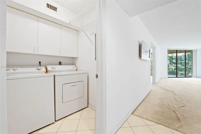 a utility room with cabinets washer and dryer