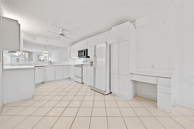a large white kitchen with white cabinets and white appliances