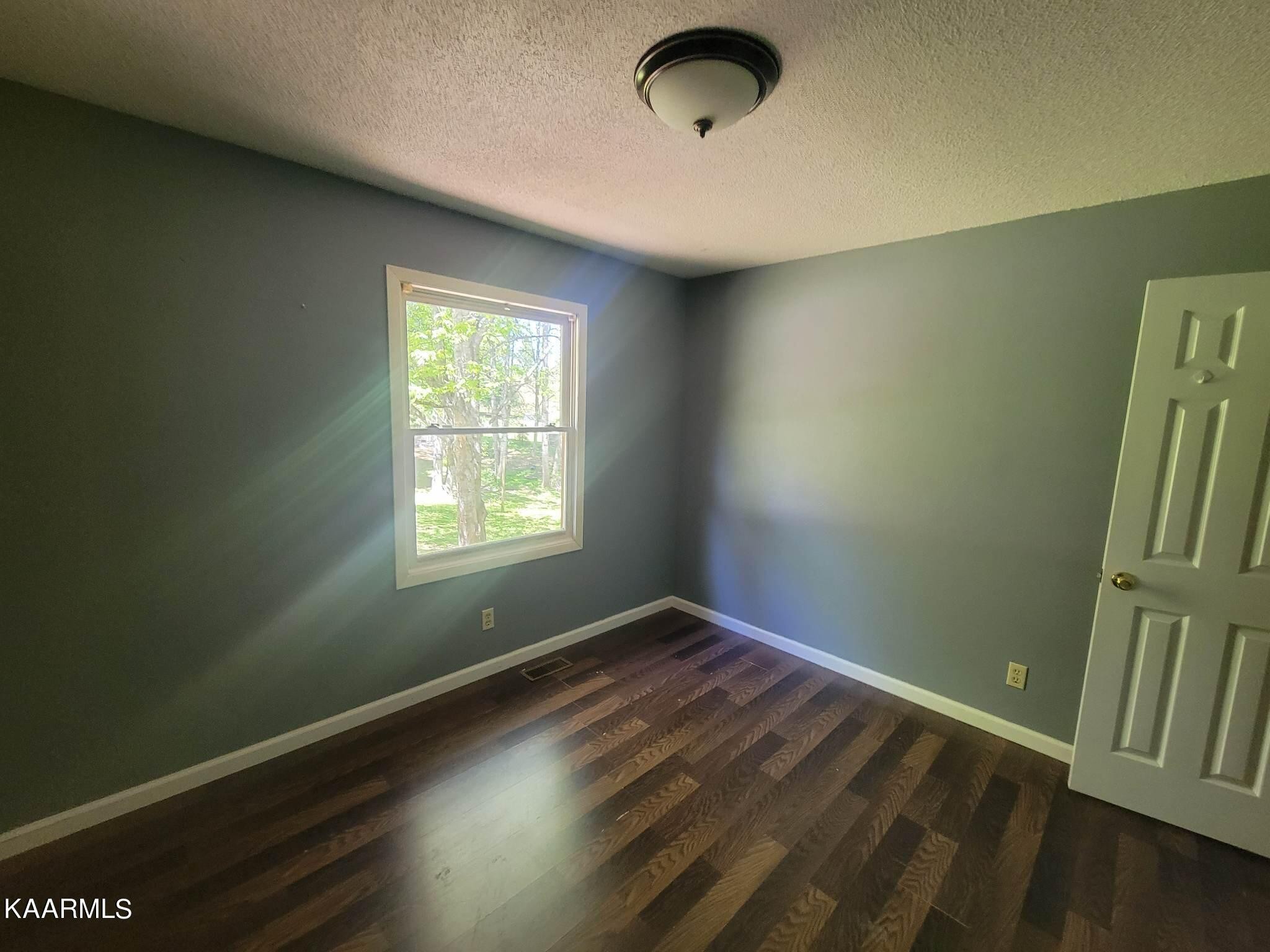 1054 Franklin Loop Clarkrange, TN 38553 - Photo 15 of 35 an empty room with wooden floor and windows