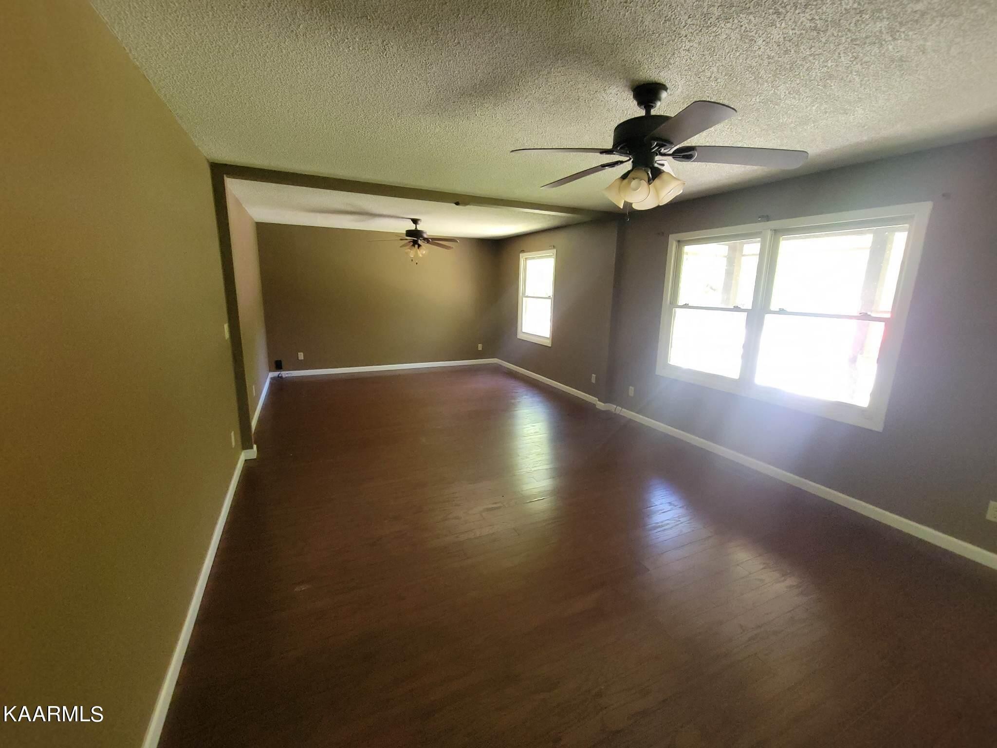 1054 Franklin Loop Clarkrange, TN 38553 - Photo 7 of 35 an empty room with wooden floor fan and windows