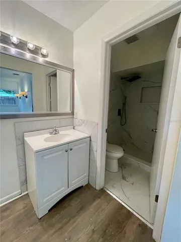 a bathroom with a sink a toilet and shower