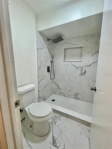 a bathroom with a toilet and a shower