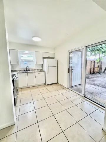 a kitchen with a stove a refrigerator and cabinets