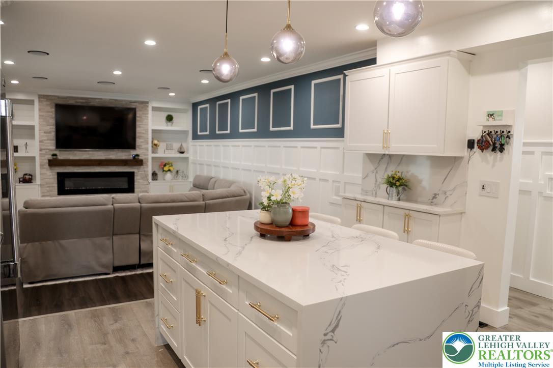 1412 Stanford Road Bethlehem, PA 18018 - Photo 19 of 58 An inviting open-concept living space features a spacious kitchen island, built-in shelving, and a modern fireplace.