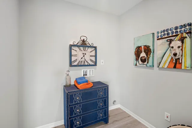 a view of a dresser with paintings on the wall