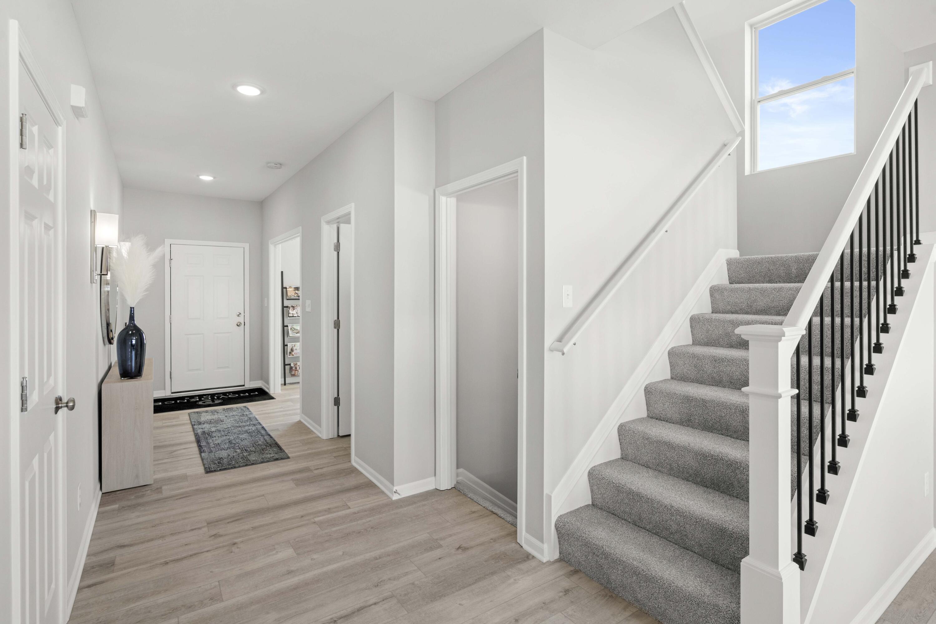 6754 East 103rd Avenue Crown Point, IN 46307 - Photo 2 of 17 a view of an entryway with wooden floor and staircase