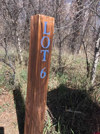 a sign board with tree in the background