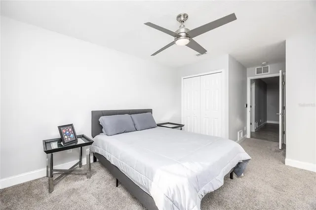 a spacious bedroom with a bed and a chandelier