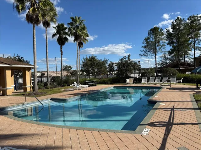 a view of backyard with swimming pool and seating space