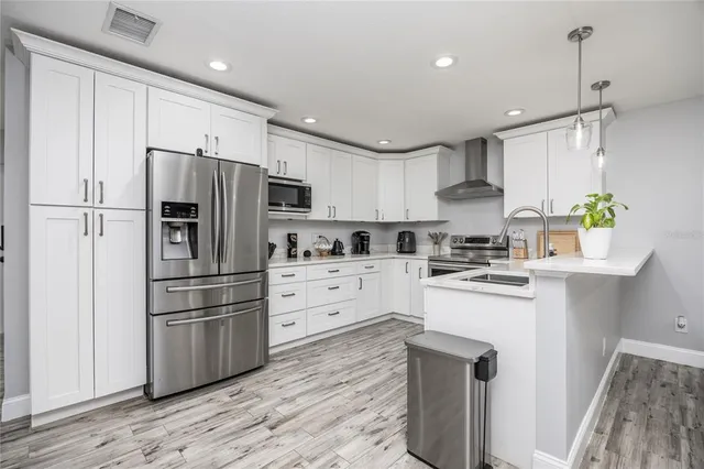 a kitchen with stainless steel appliances a refrigerator sink and microwave