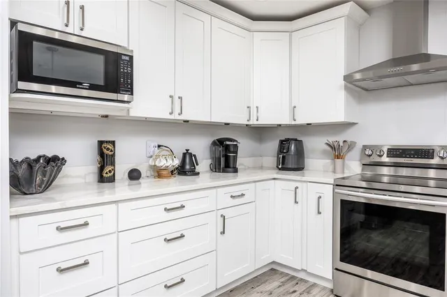 a kitchen with white cabinets and appliances