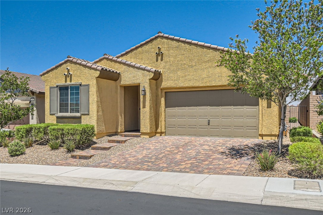 498 Pebble Run Avenue Henderson, NV 89011 - Photo 1 of 47 A well-maintained stucco home with a tile roof and inviting brick paver driveway.