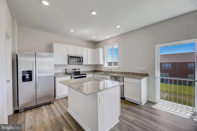 a kitchen with granite countertop a refrigerator and a sink