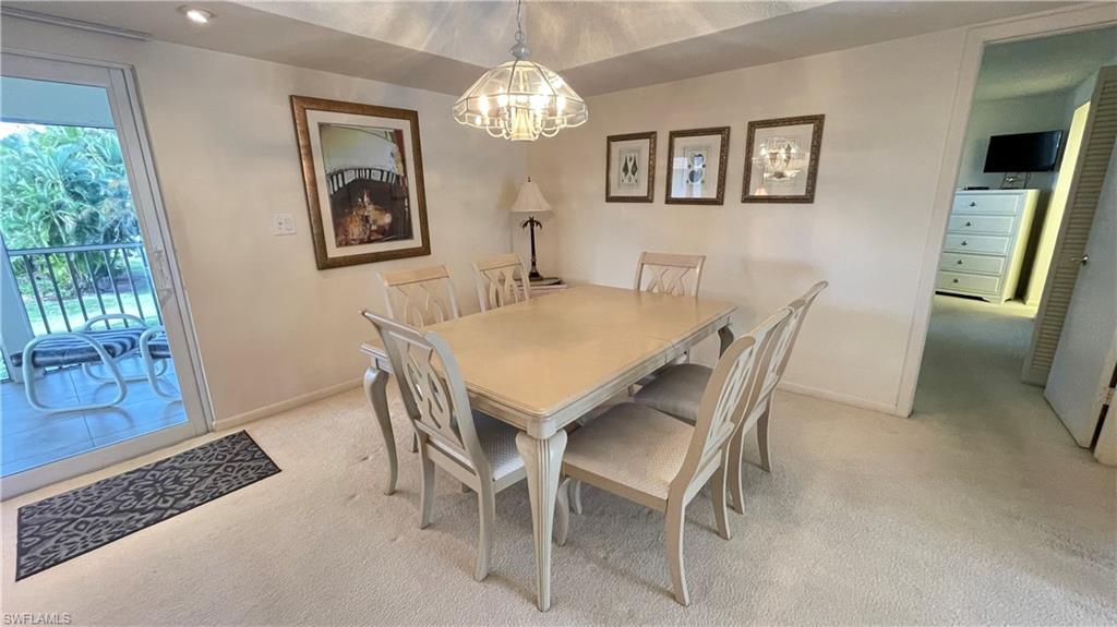 801 Teryl Road, Unit 4 Naples, FL 34112 - Photo 11 of 19 Dining space with light carpet and suspended lighting