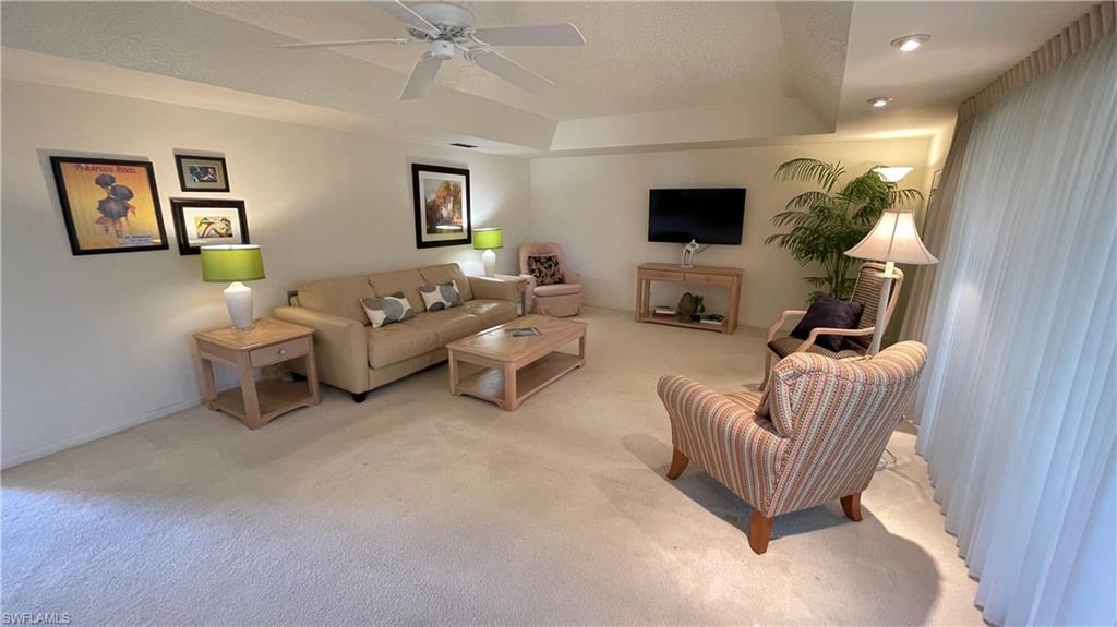 801 Teryl Road, Unit 4 Naples, FL 34112 - Photo 13 of 19 Cozy living room featuring carpet floors, a raised ceiling, and ceiling fan