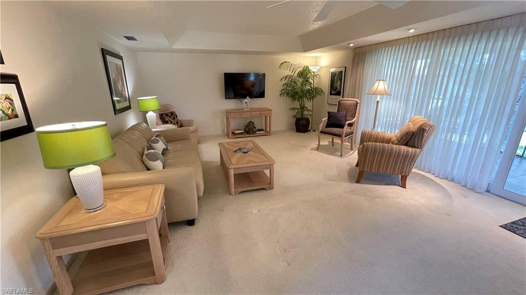 801 Teryl Road, Unit 4 Naples, FL 34112 - Photo 3 of 19 Living room with carpet floors, a tray ceiling, and a ceiling fan