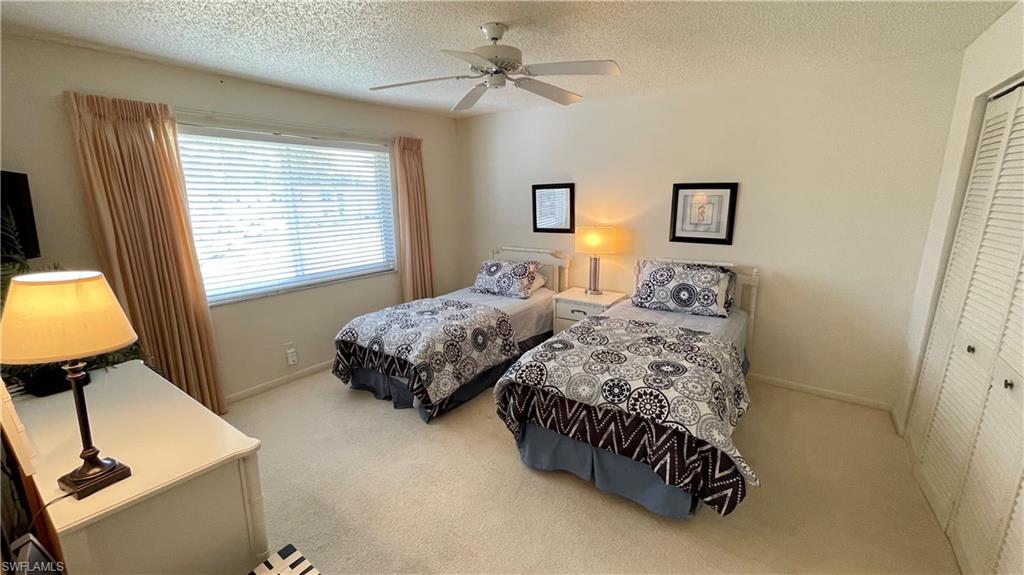 801 Teryl Road, Unit 4 Naples, FL 34112 - Photo 5 of 19 Carpeted bedroom featuring a closet, ceiling fan, and a textured ceiling