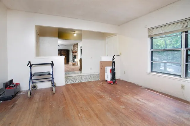 a living room with furniture tv and a floor to ceiling window