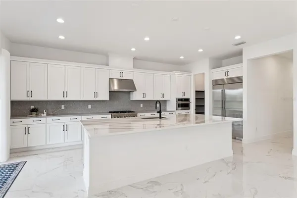 a large kitchen with stainless steel appliances lots of counter top space and cabinets