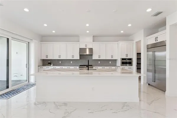 a kitchen with stainless steel appliances granite countertop a sink stove and cabinets