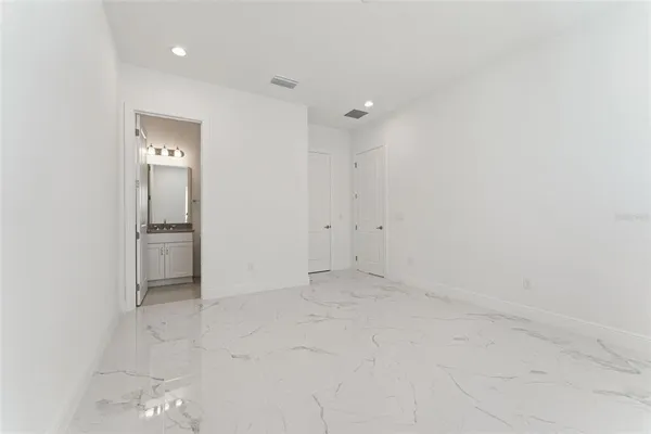 a large bathroom with a double vanity sink a toilet a mirror and shower
