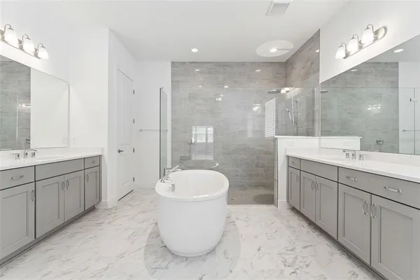 a bathroom with a bathtub shower sink mirror and toilet