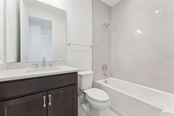 a bathroom with a granite countertop sink and a toilet