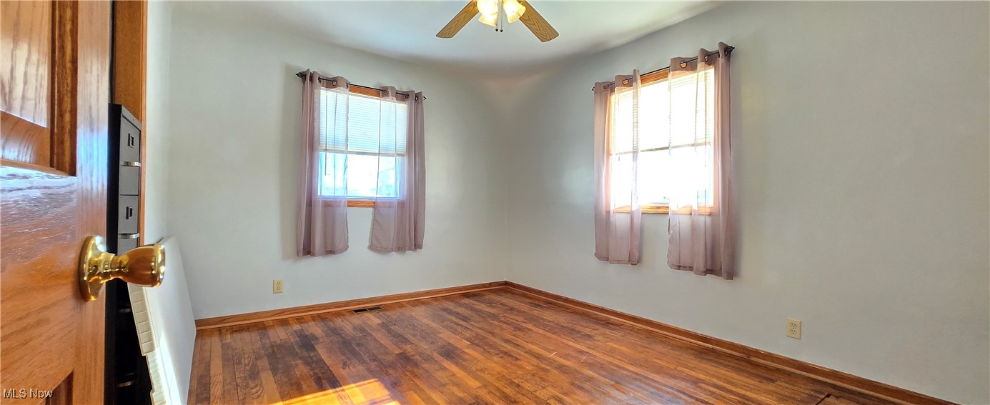 5217 McCartney Road Sandusky, OH 44870 - Photo 11 of 17 Spare room with hardwood / wood-style flooring, a wealth of natural light, and ceiling fan