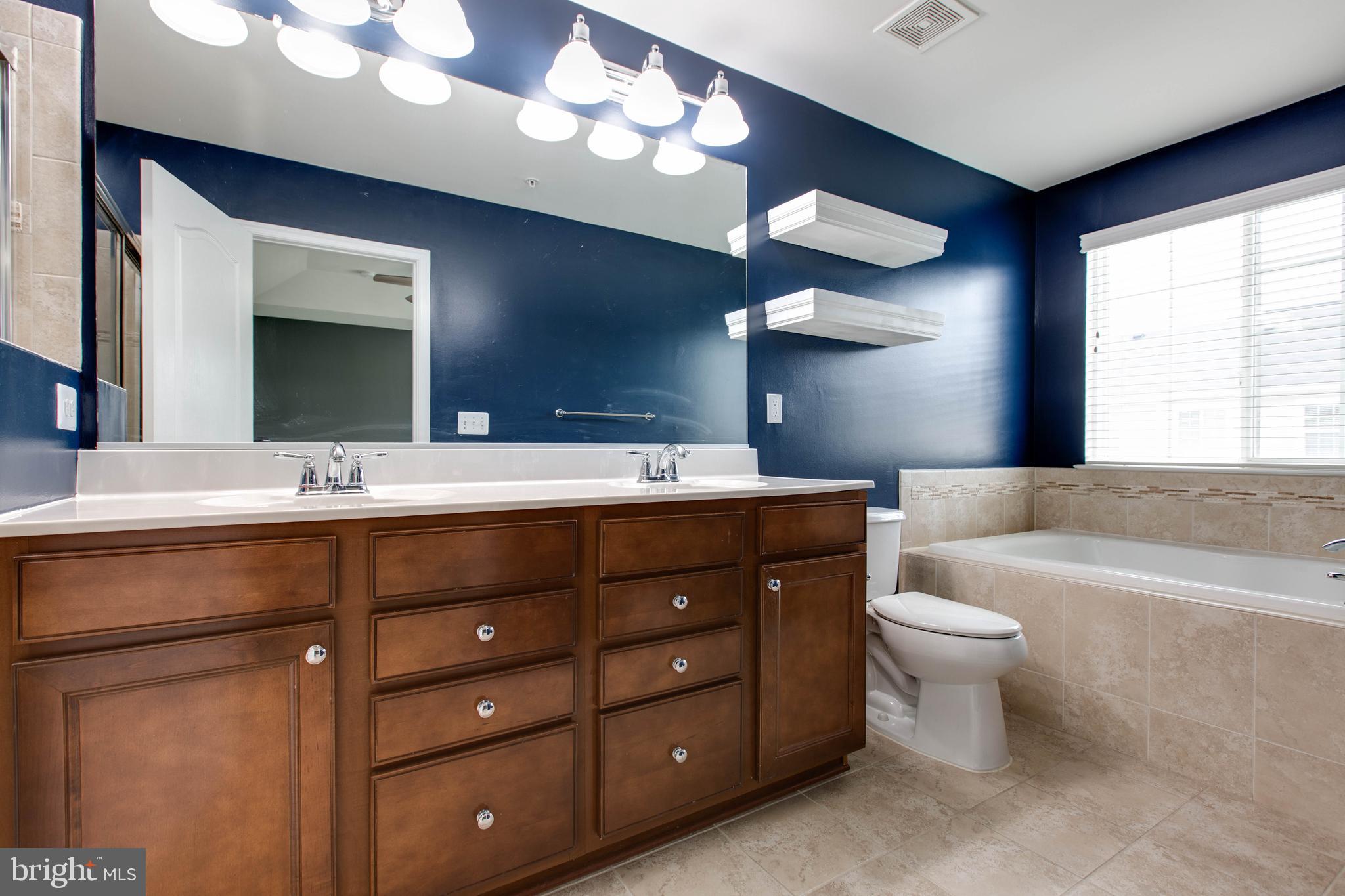 7926 Silver Oak Road Hanover, MD 21076 - Photo 27 of 44 a bathroom with a double vanity sink a toilet and a large mirror