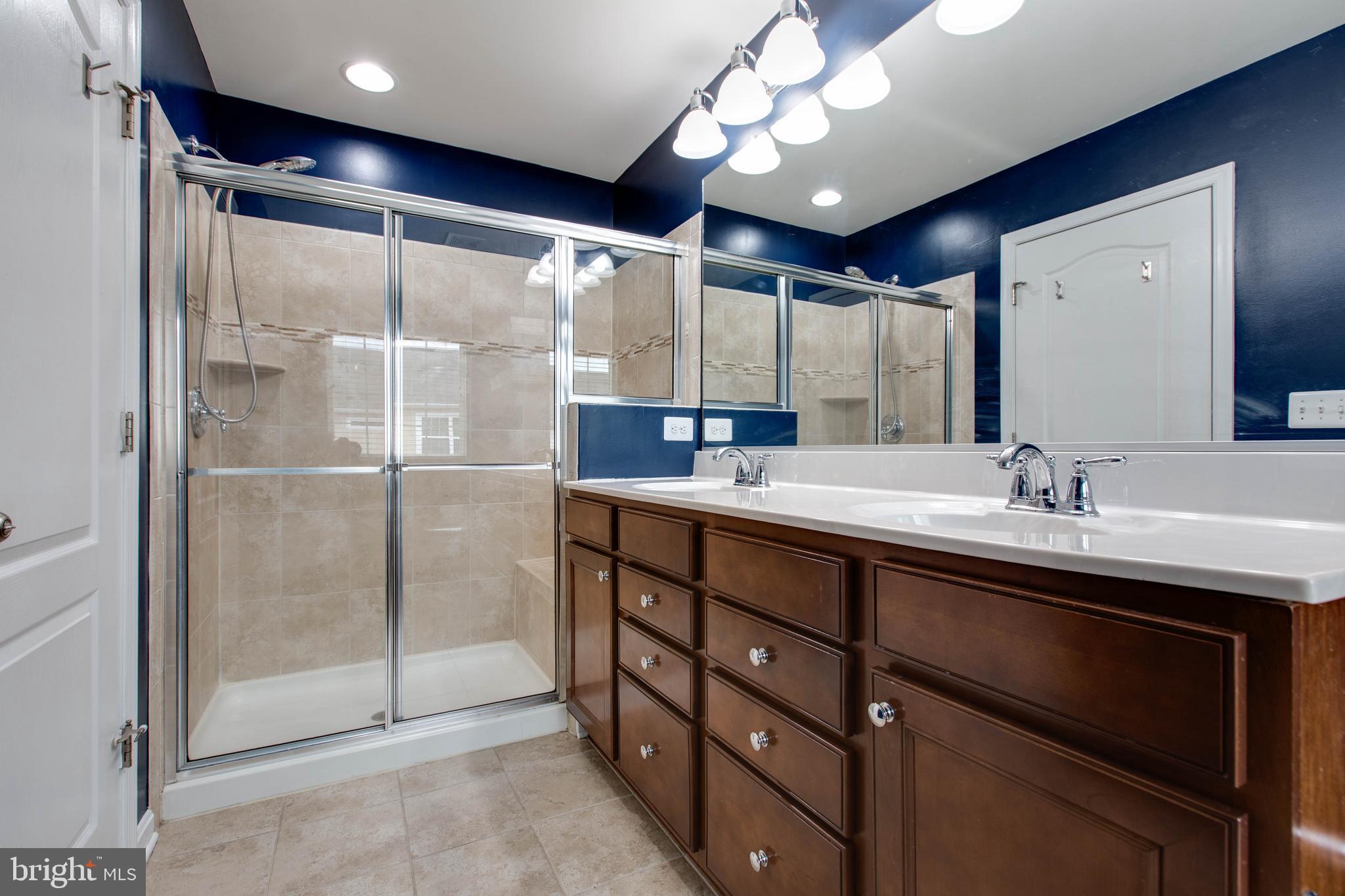 7926 Silver Oak Road Hanover, MD 21076 - Photo 28 of 44 a bathroom with a double vanity sink mirror and shower