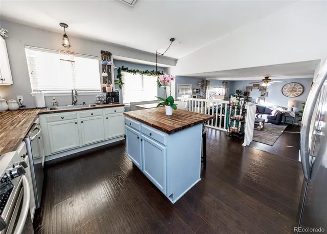 a kitchen with granite countertop center island wooden floor stainless steel appliances and cabinets