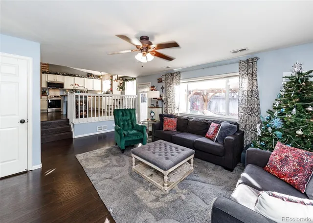 a living room with furniture a chandelier and a window
