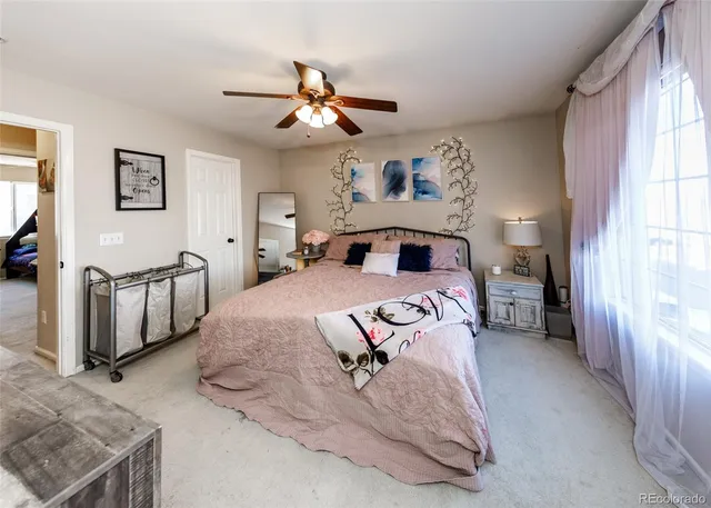 a spacious bedroom with a bed and a chandelier