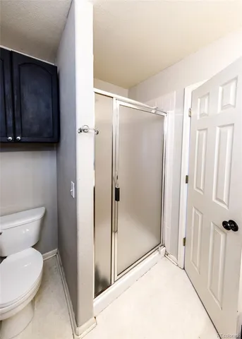 a bathroom with a toilet and a shower