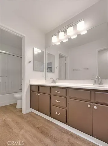 a spacious bathroom with a granite countertop sink a toilet a mirror and shower