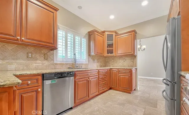 a kitchen with stainless steel appliances granite countertop a sink and a refrigerator