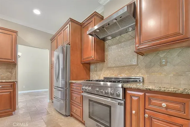 a kitchen with stainless steel appliances granite countertop a refrigerator and a stove