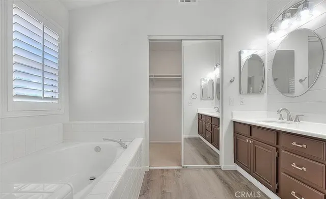 a spacious bathroom with a tub sink and mirror