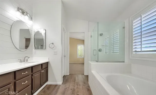a spacious bathroom with a tub sink mirror and vanity