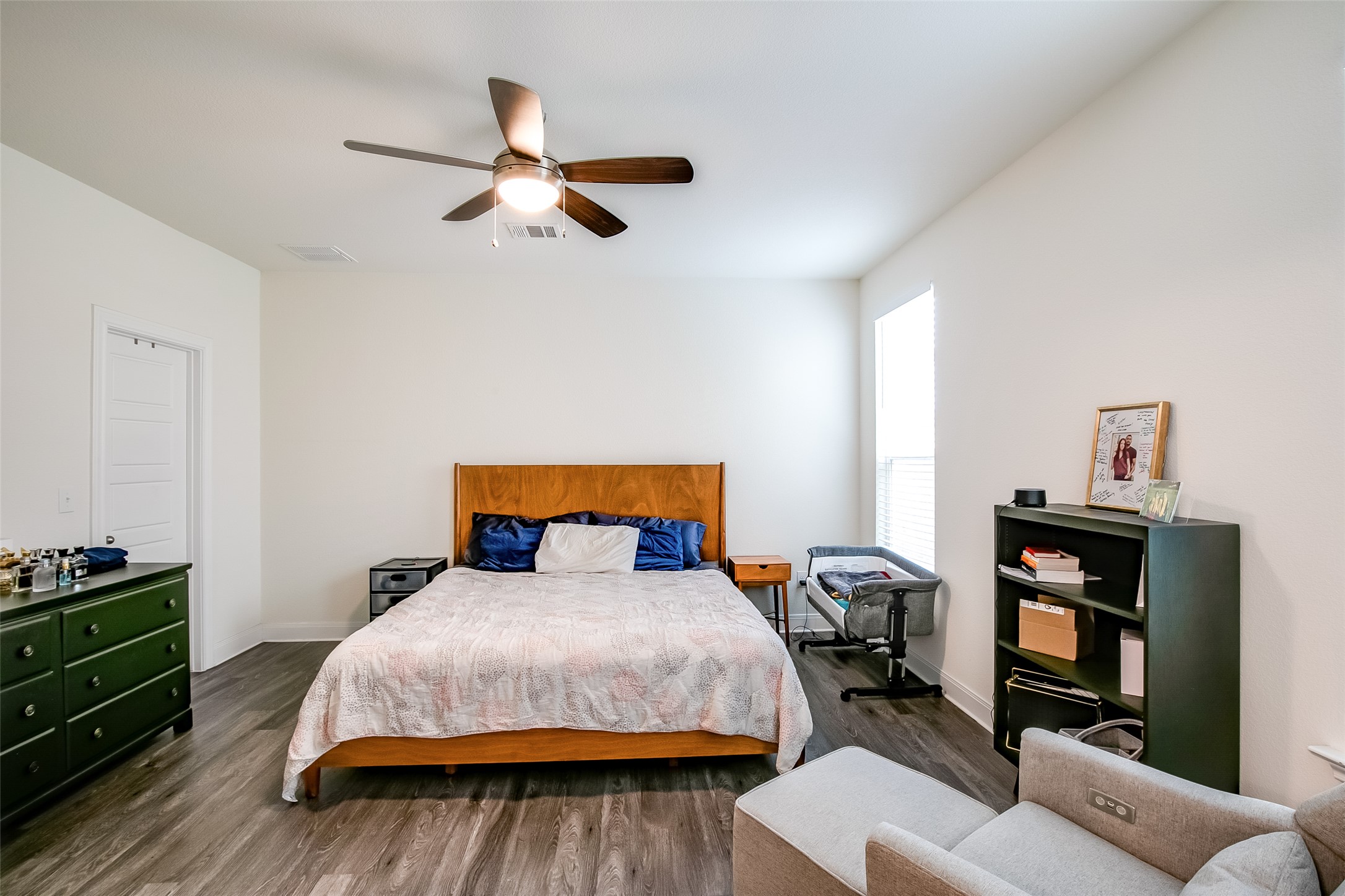 7616 Groundhog Way Austin, TX 78744 - Photo 18 of 34 a bedroom with a bed and wooden floor
