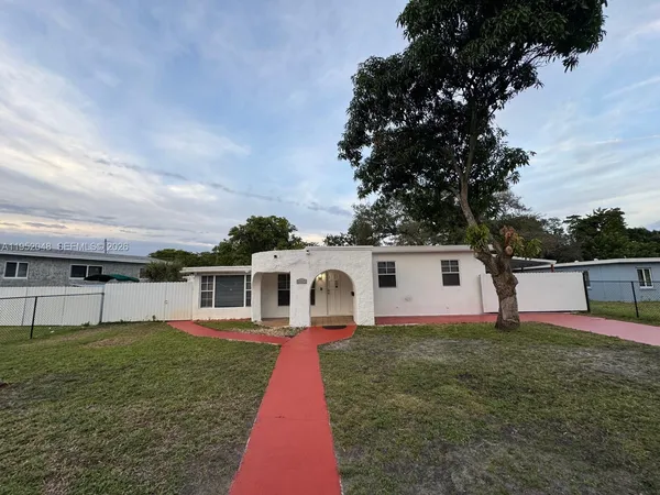 a front view of a house with a yard and trees