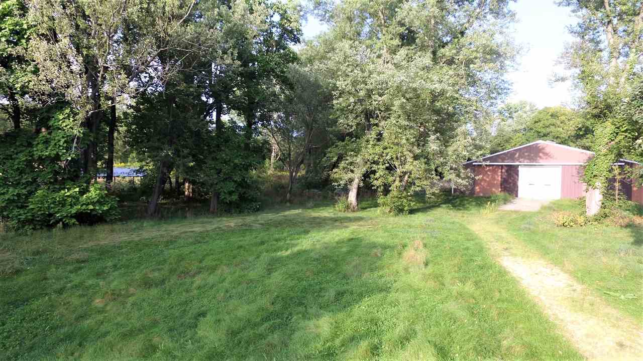 8502 Burr Oak Road Roscoe, IL 61073 - Photo 7 of 14 a backyard of a house with plants and large trees