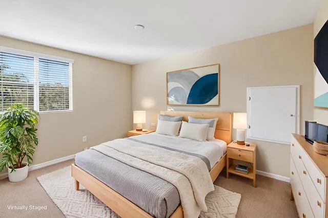 a bedroom with a bed and a potted plant