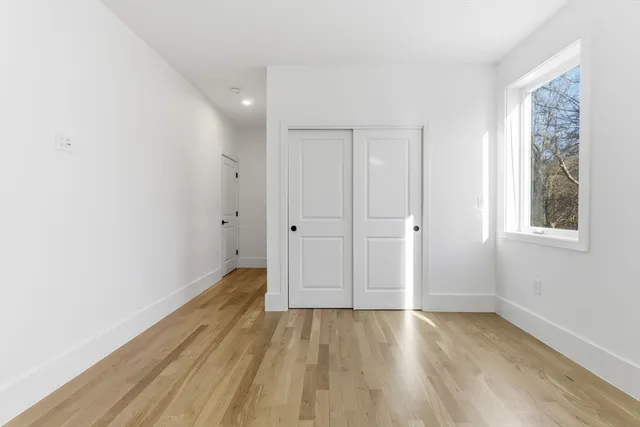 a view of a room with wooden floor and window