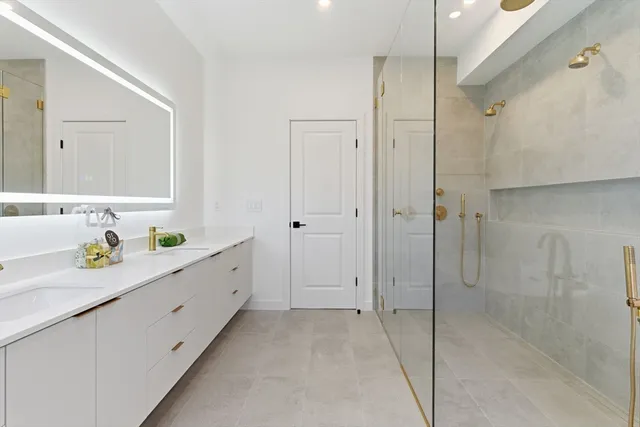 a bathroom with a double vanity sink toilet and shower